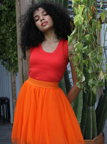 Pretty girl wearing a bright orange short tulle skirt