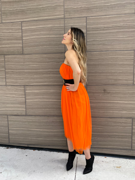Pretty woman wearing an orange tulle skirt as a skirt and as a dress