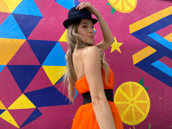 Pretty woman wearing an orange tulle skirt as a skirt and as a dress