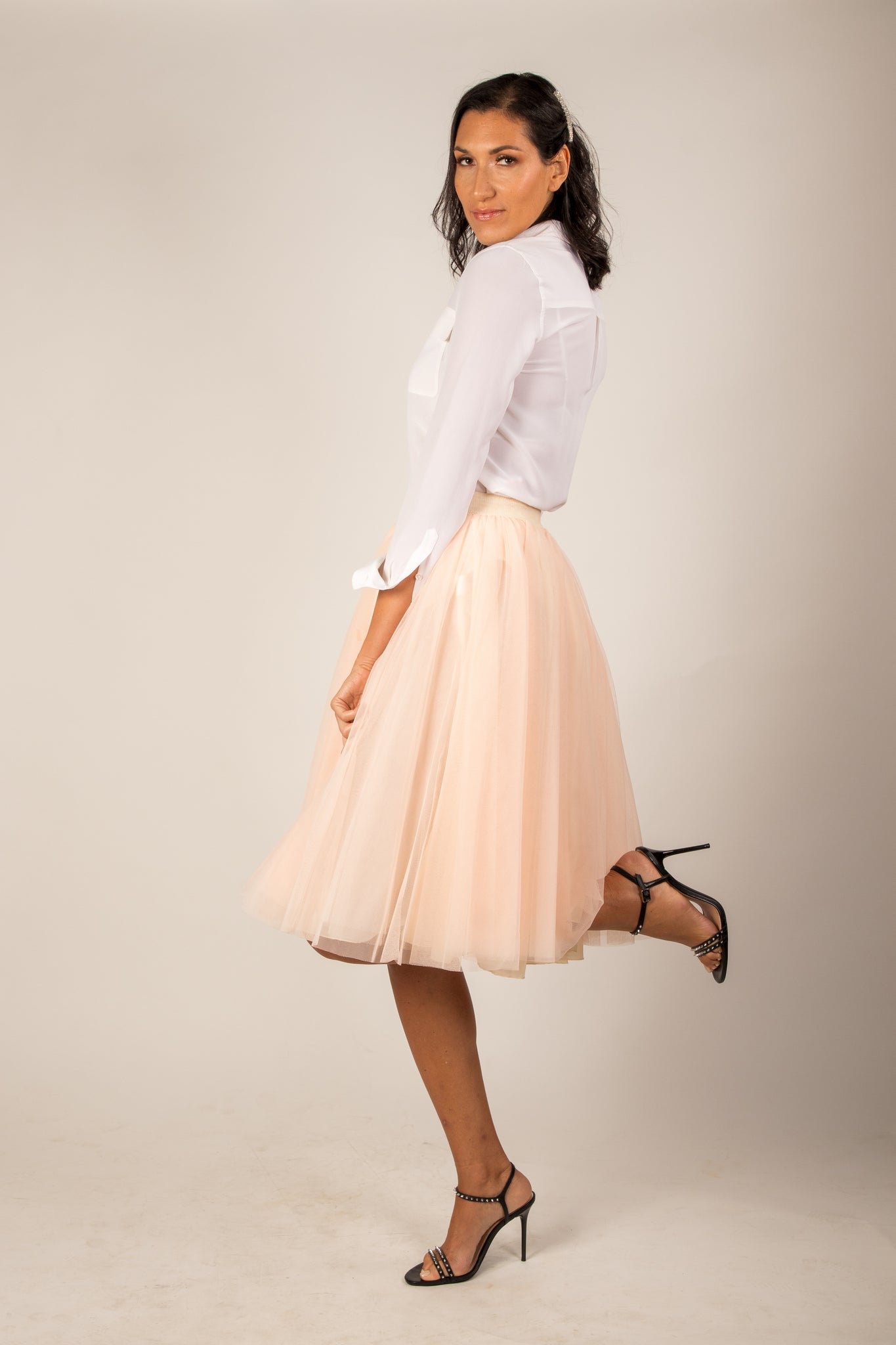 A tall model wearing the Midi Champagne tulle skirt